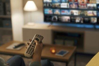 Young woman watching video on demand on her TV